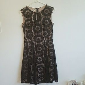 Fit and flare dress with black lace over nude.